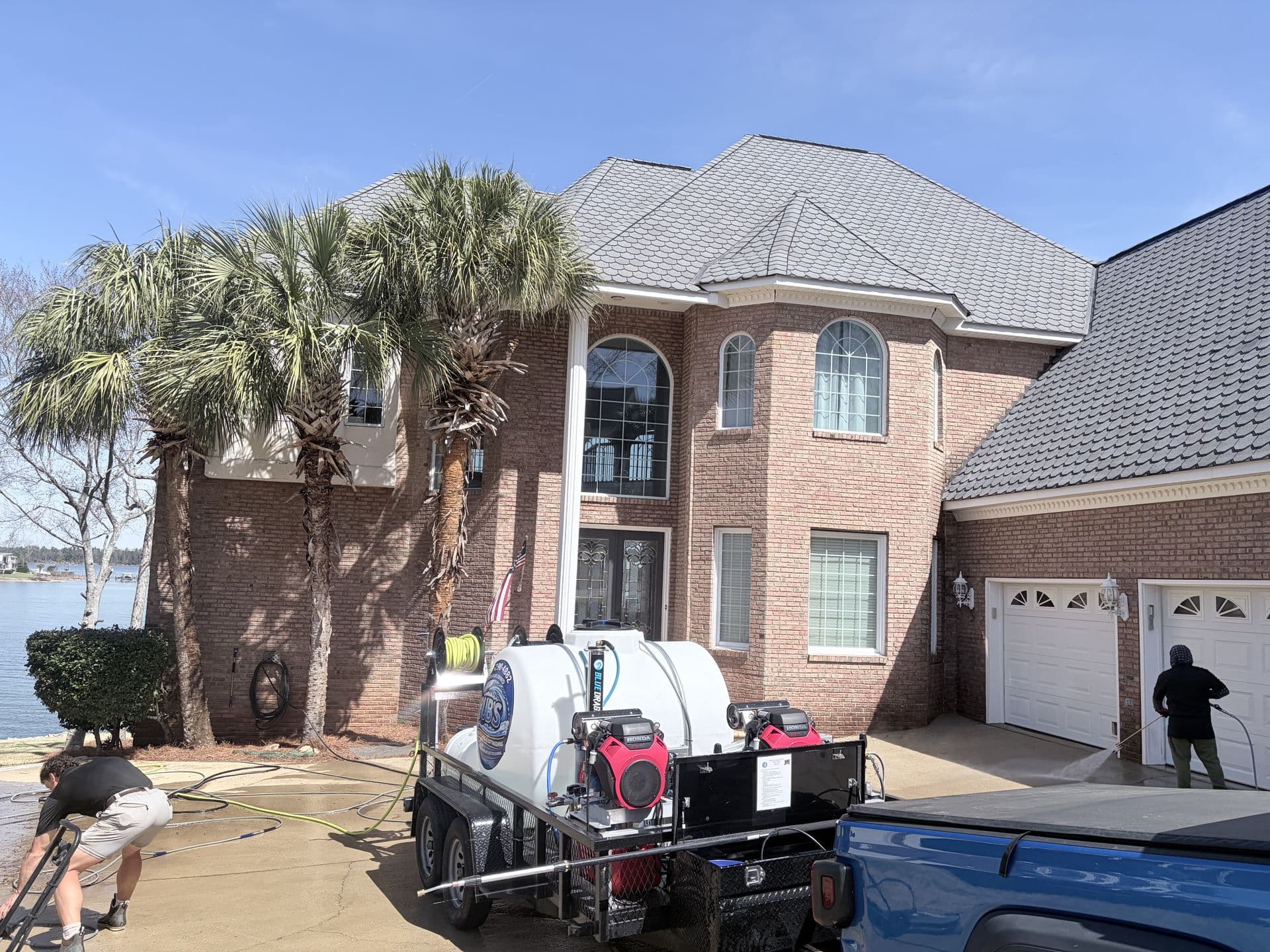 Bub's Pressure Washing rig and crew working at a lakefront home