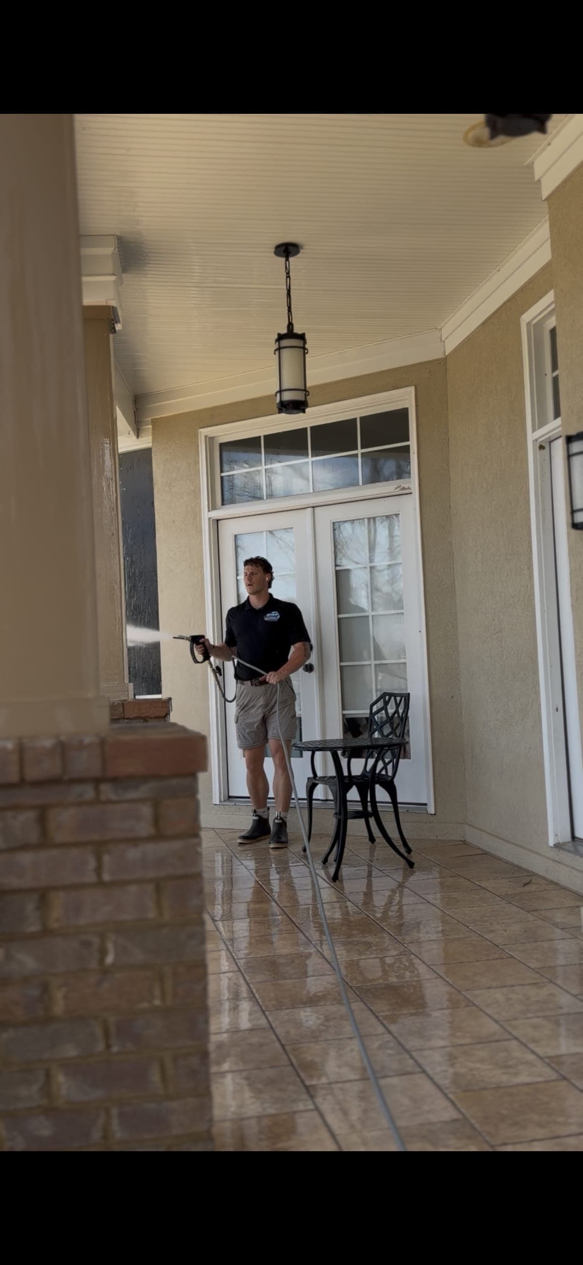Technician pressure washing a covered porch at a Lake Murray, SC home